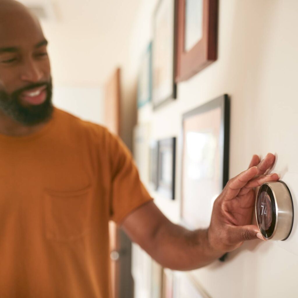 man setting the thermostat on new hvac installation